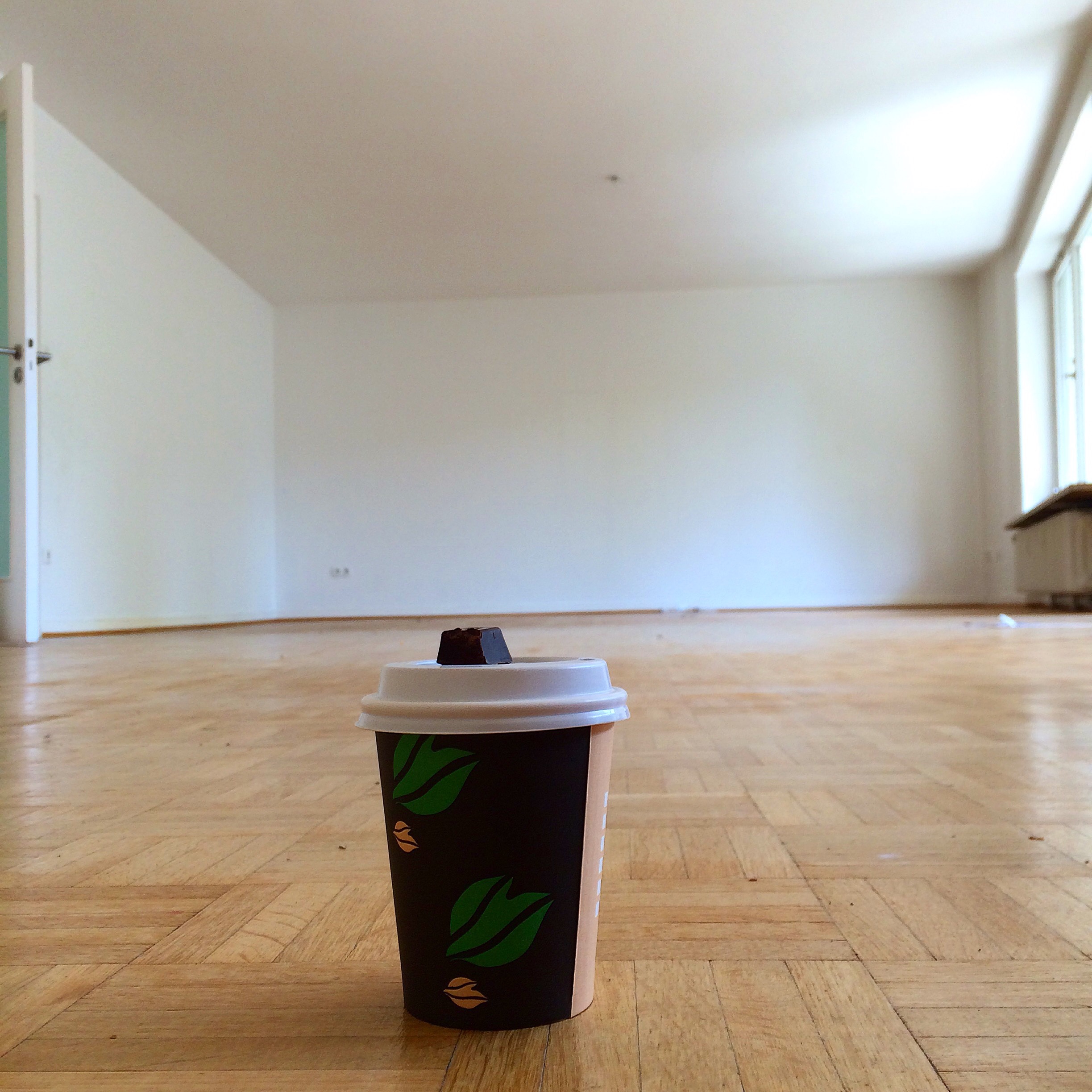 Kaffekop på stort, tomt golv